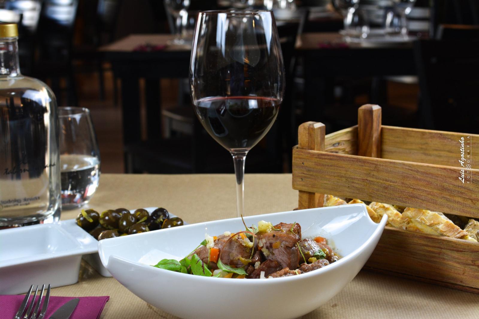 Prato de picapau com legumes e copo de vinho tinto no Dux