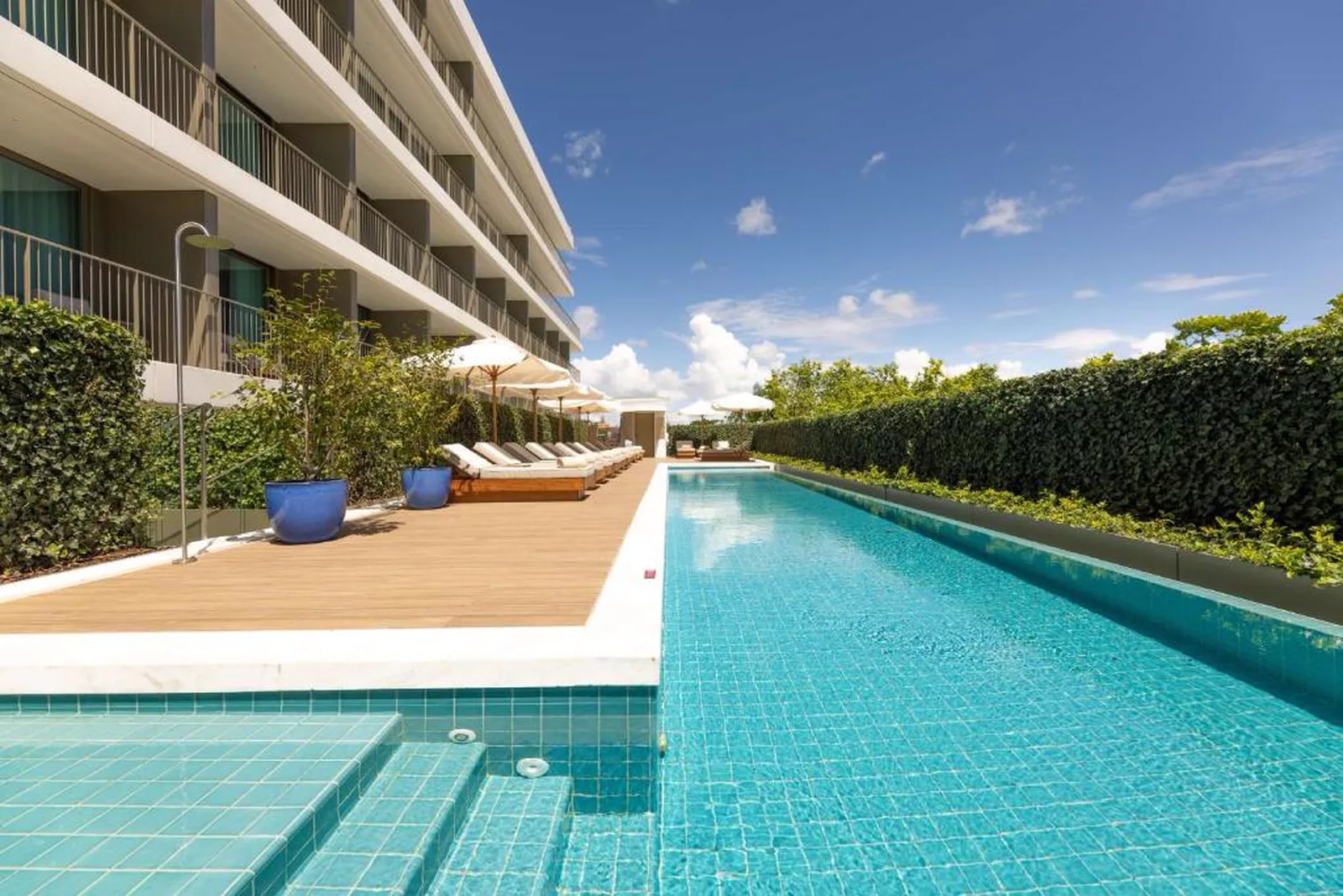 Piscina exterior do Legacy Hotel Cascais com espreguiçadeiras e deck de madeira