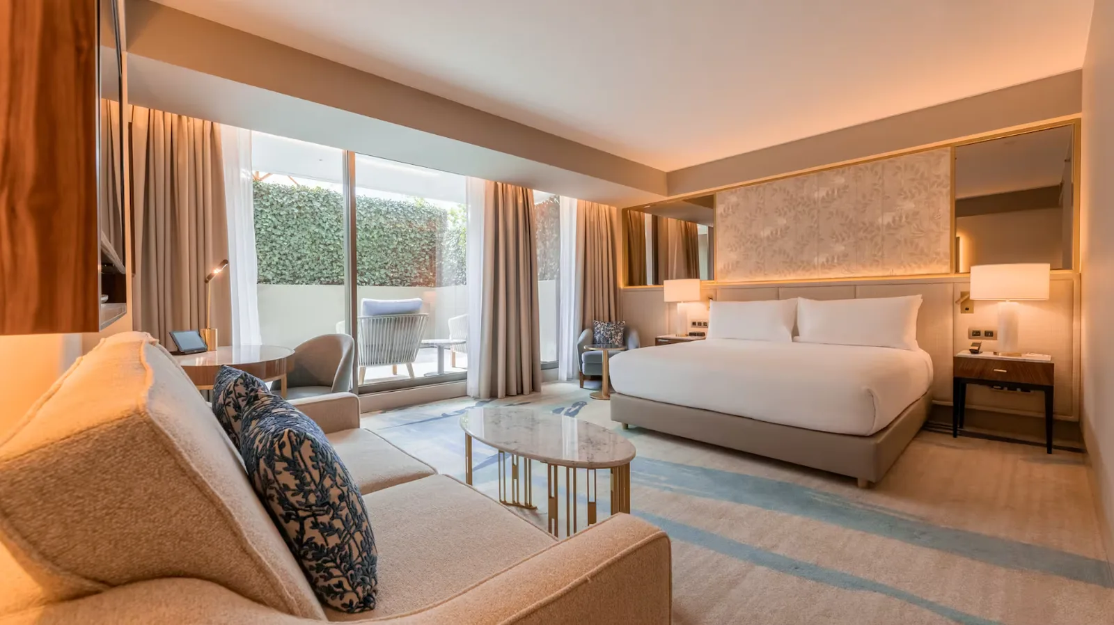 Quarto do Legacy Hotel Cascais com cama king size, sofá e varanda privada
